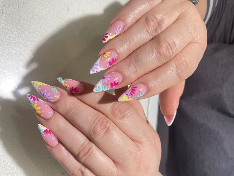 Pink almond nails with pastel yellow tips and 3D pink flowers