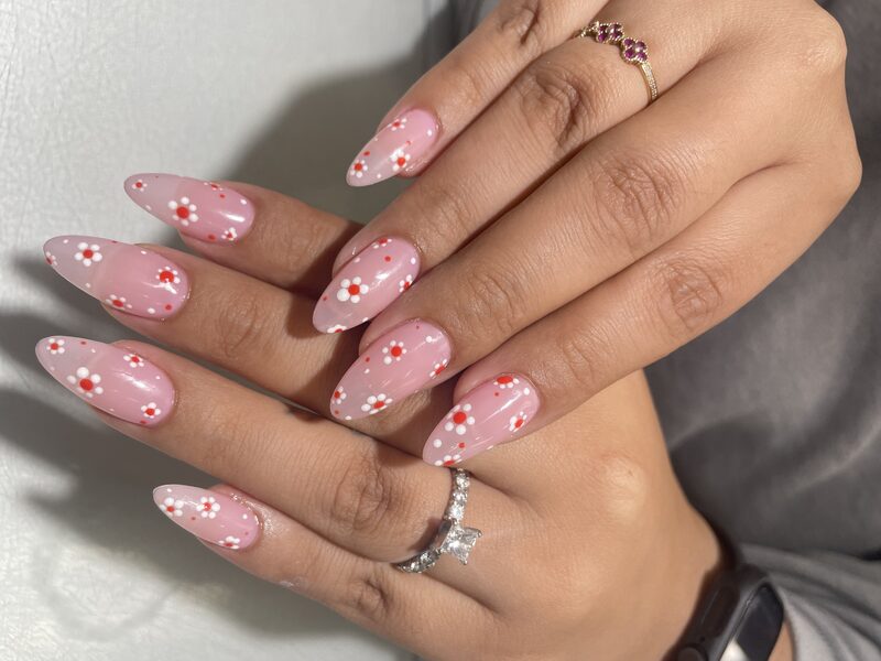 Pink almond nails with red and white daisy detail