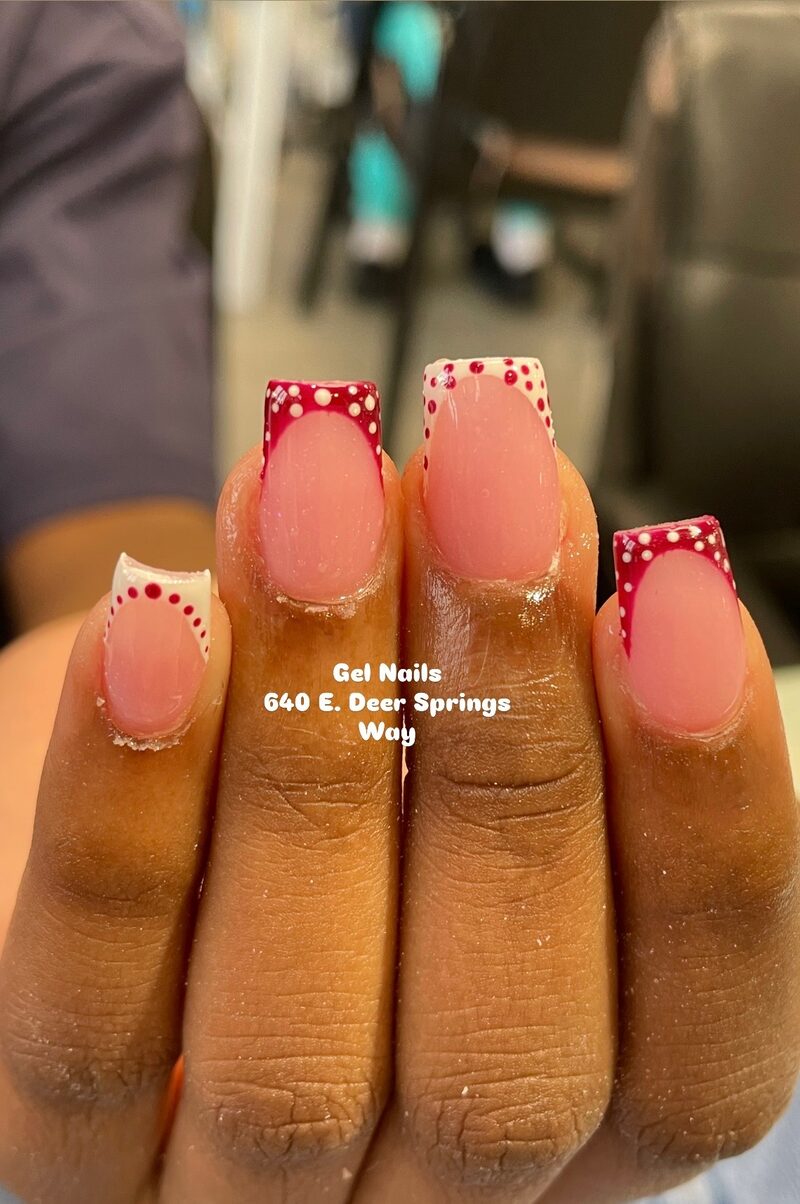 Close-up of red polka dot french tip design